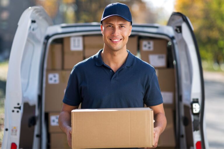 Delivery Man smiling holding a package in front of his truck